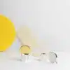 Duo de salière et poivrier de la collection Houlgate de Puiforcat en argent massif mis en scène devant des formes géométriques de couleur jaune