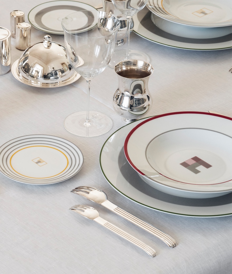 Table dressée de pièces en métal argenté et assiettes à pain, creuse et à dîner de la collection Monogrammes de Puiforcat
