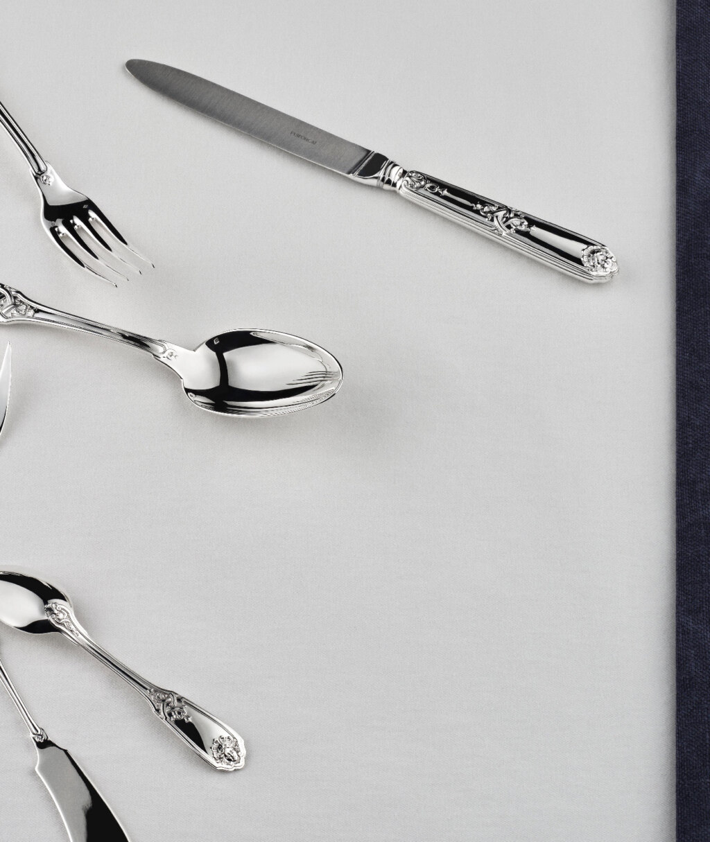 Pieces of table cutlery in sterling silver from Molière Mascaron collection from Puiforcat on a with tablecloth