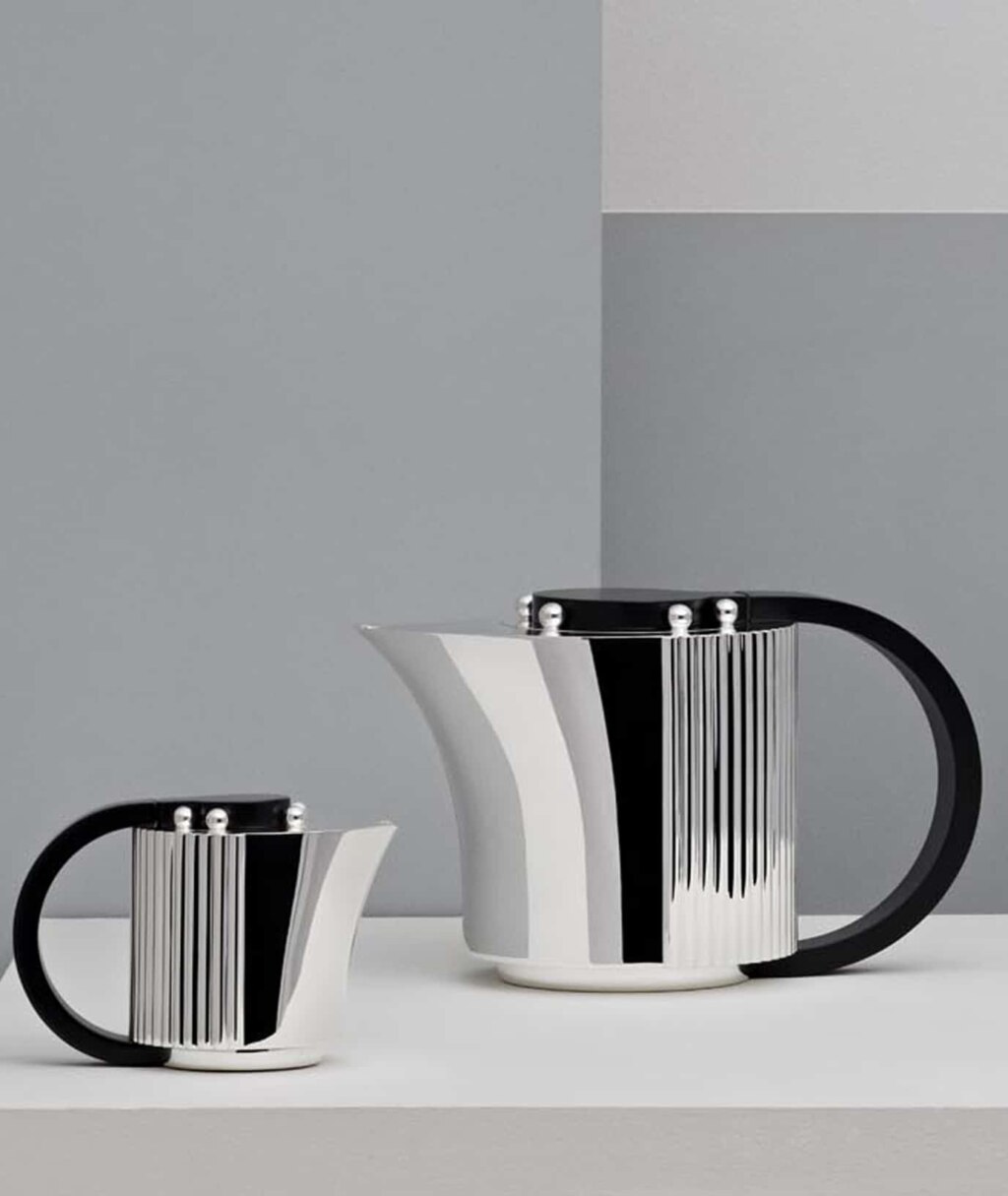 Silver plated coffee pot and creamer from Etchéa 1937 collection photographed in front of a grey and blue background