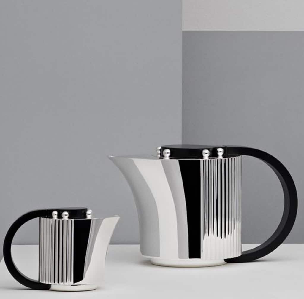 Silver plated coffee pot and creamer from Etchéa 1937 collection photographed in front of a grey and blue background