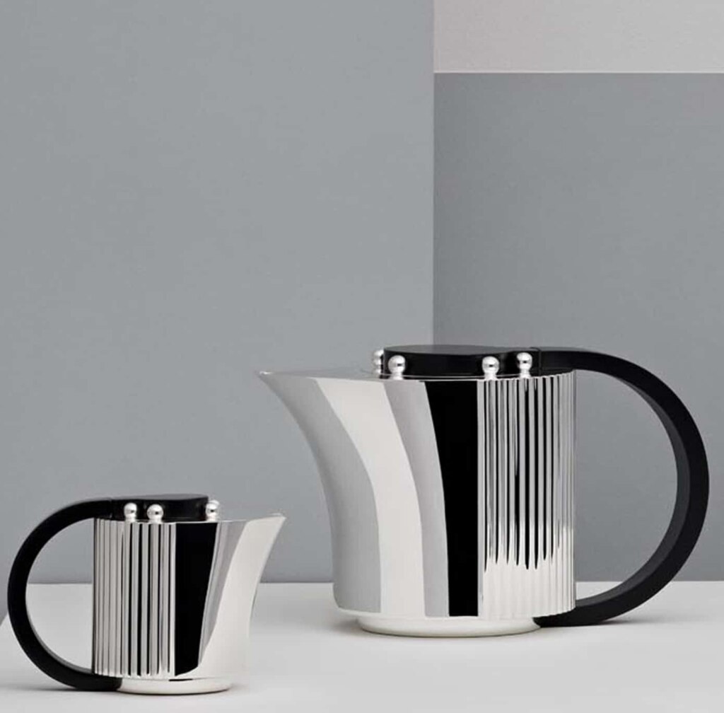 Silver plated coffee pot and creamer from Etchéa 1937 collection photographed in front of a grey and blue background