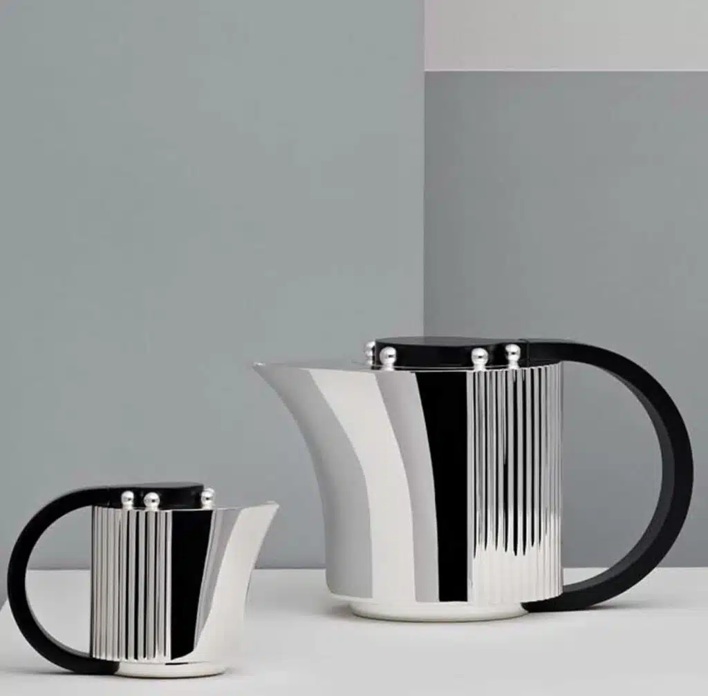 Silver plated coffee pot and creamer from Etchéa 1937 collection photographed in front of a grey and blue background