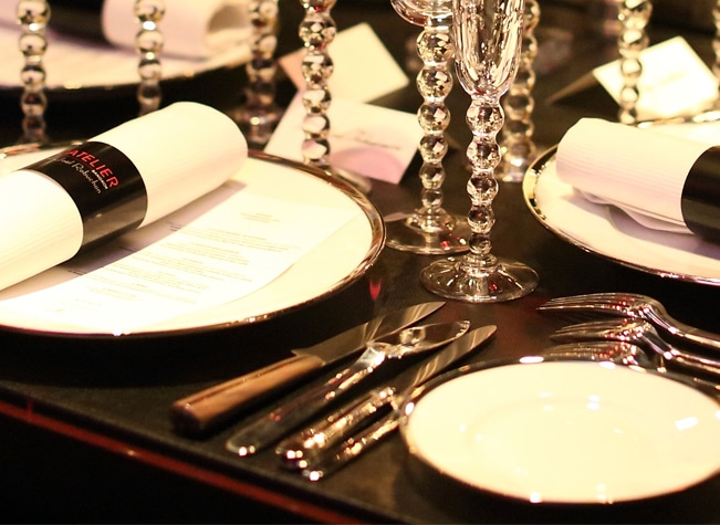 Pieces of table cutlery from Louvois and Couteaux d'orfèvre collections from Puiforcat in sterling silver photographed on a dressed table of Cercle d'orfèvre collection at l'Atelier de Joël Robuchon, famous French chef