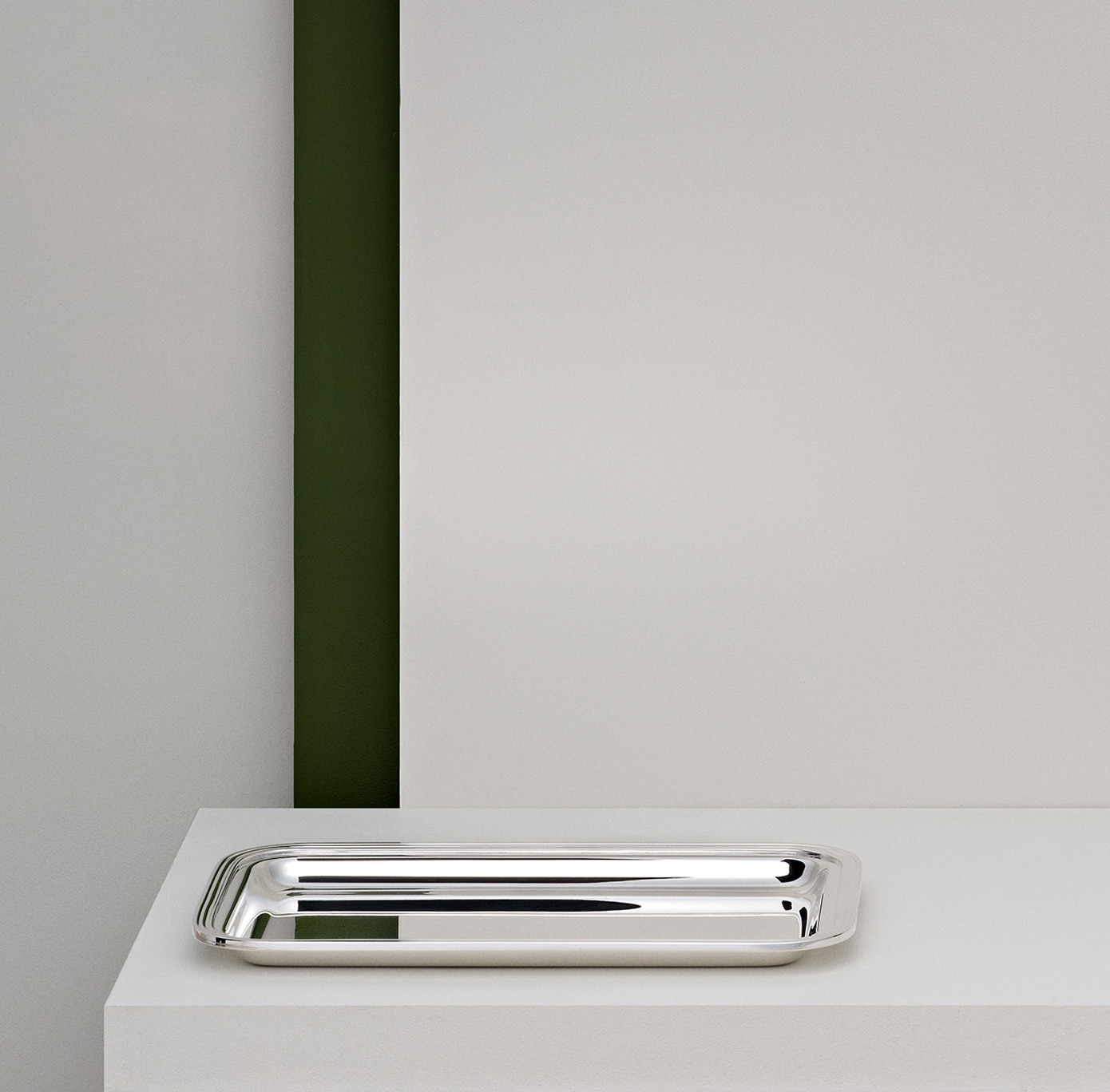 Dépêche tray in silver plated photographed on a white stele in front of a green band decoration