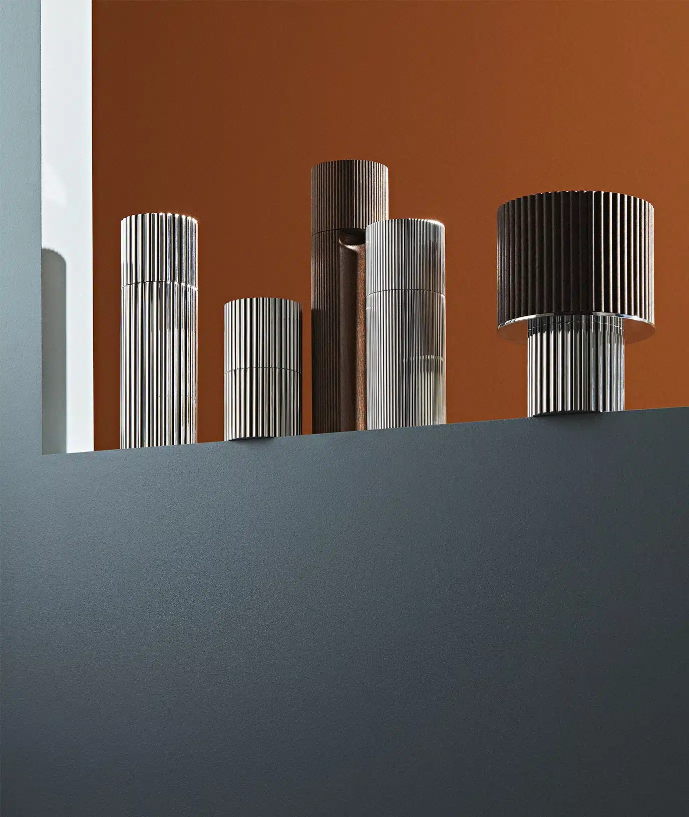 Silver plated oil dispenser, spice box, nutmeg box and salt & pepper mill from Granville collection from Puiforcat photographed on a window sill in front of an orange wall