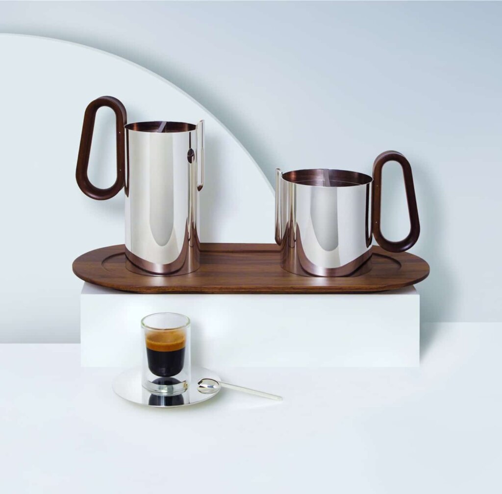 Tea pot, coffee pot, large tray expresso cup and saucer photographed from side on steles of different heights on a blue and white background