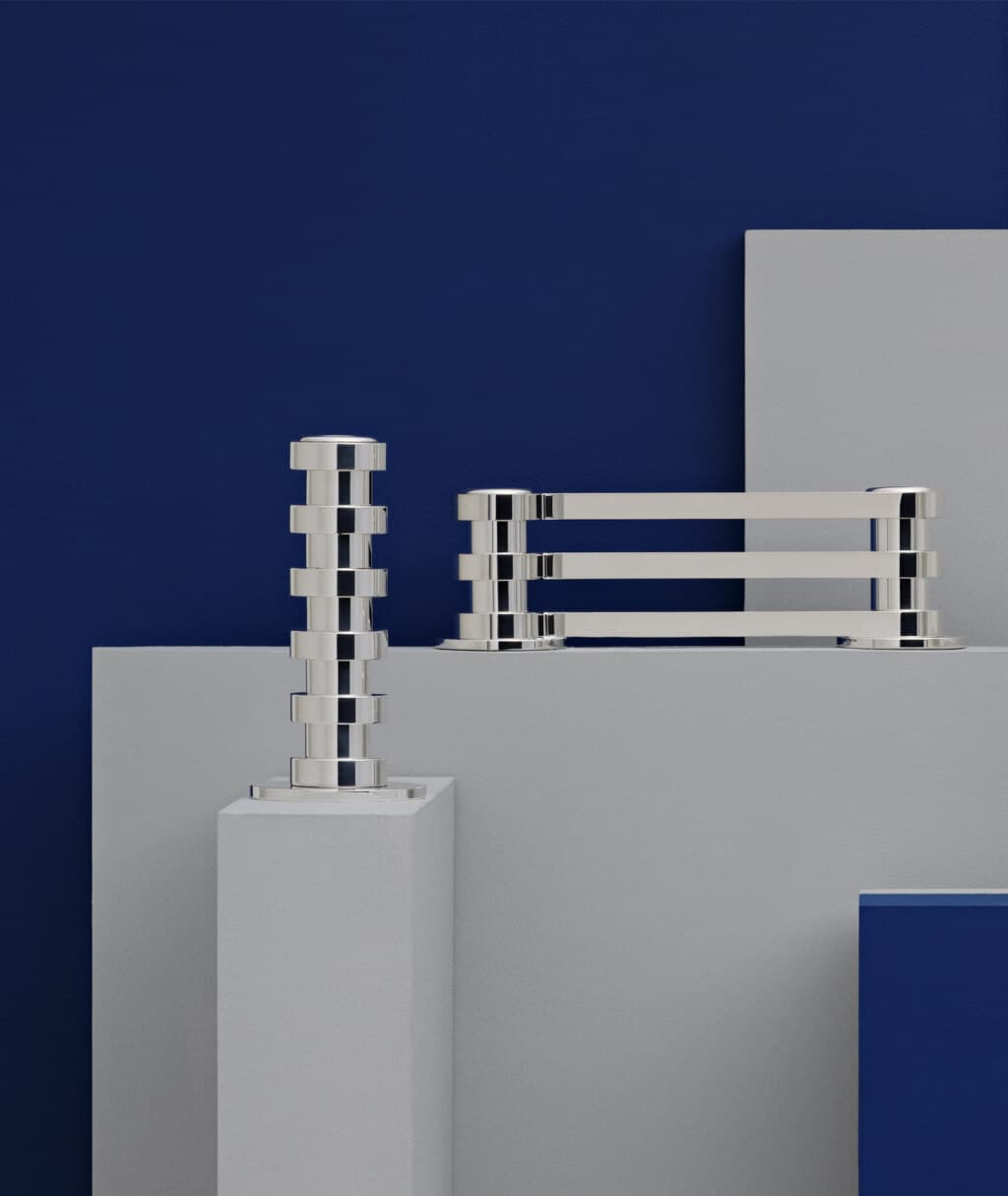Two lights candlestick in silver plated from Ruban collection from Puiforcat photographed on grey steles of different heights in front of a bleu wall
