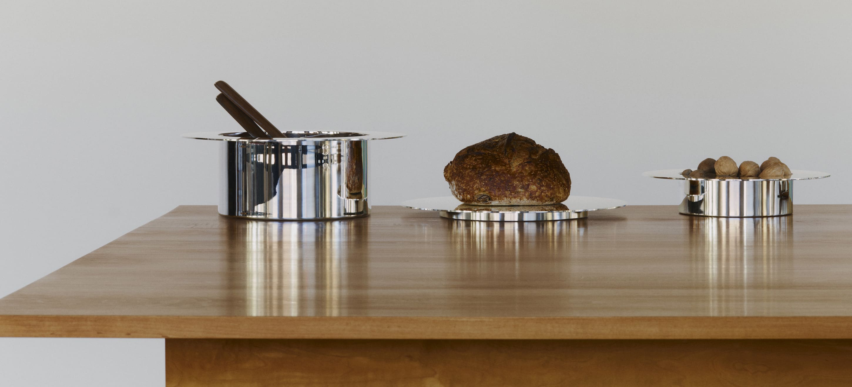 Trois pièces de la collection Dinner Service par Donald Judd posés sur une table en bois