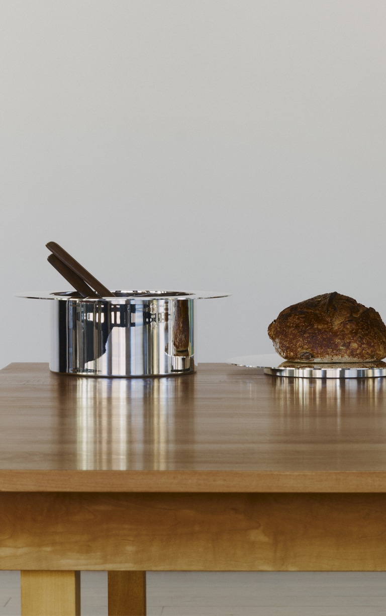 Trois pièces de la collection Dinner Service par Donald Judd posés sur une table en bois