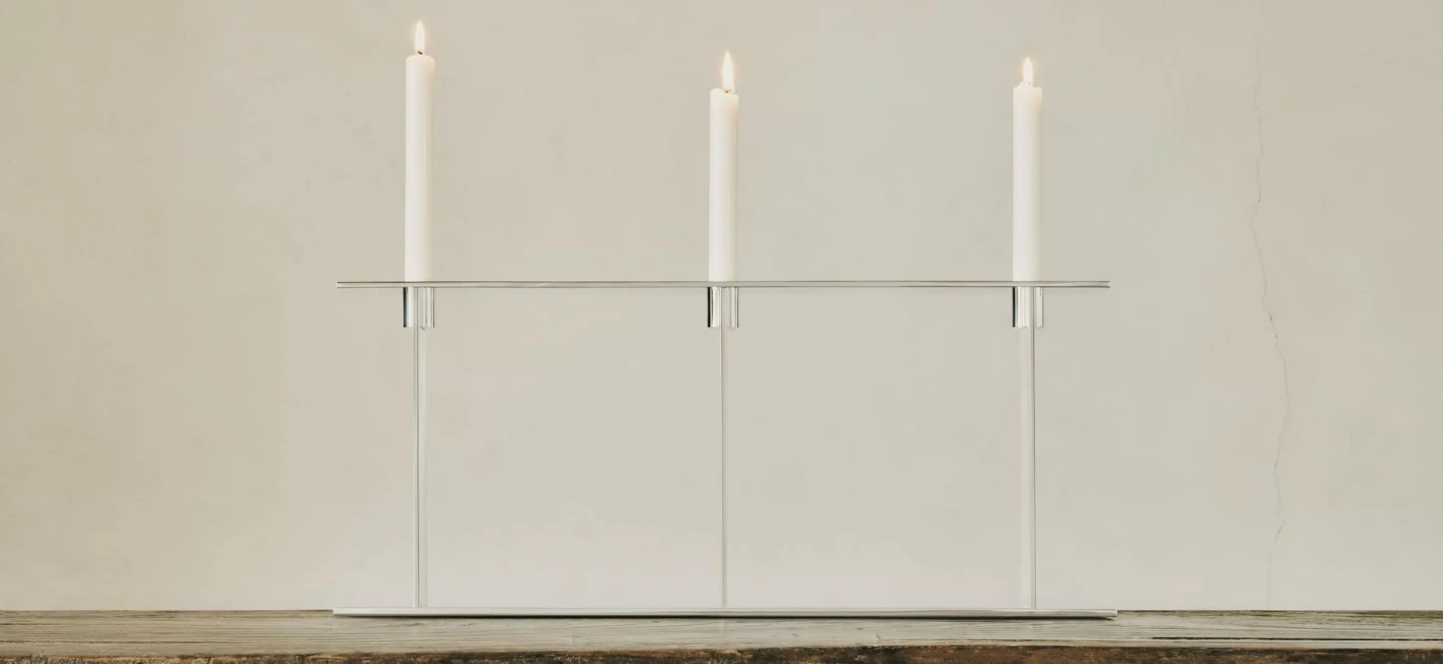 Candélabre trois lumières de la collection Pilotis, posé sur une table en bois.