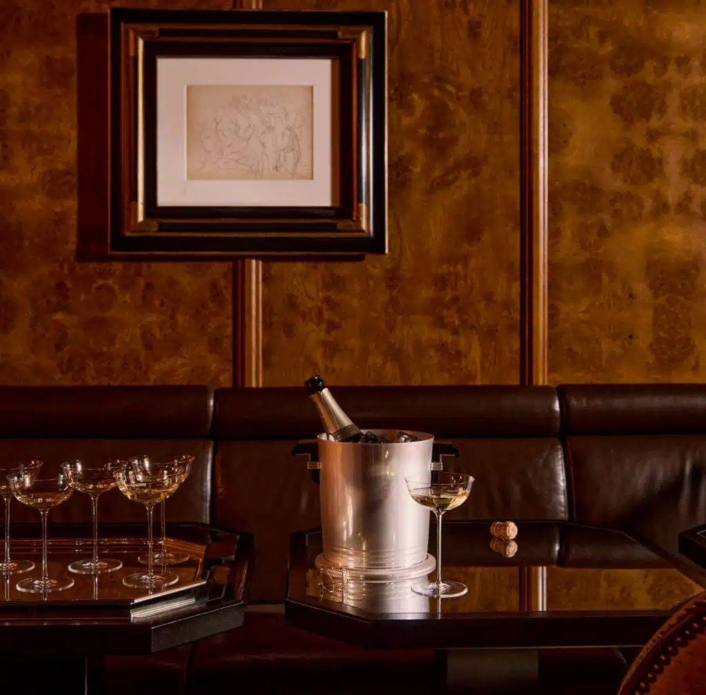 Seau à champagne de la collection Art Déco sur une table en bois avec une coupe à champagne