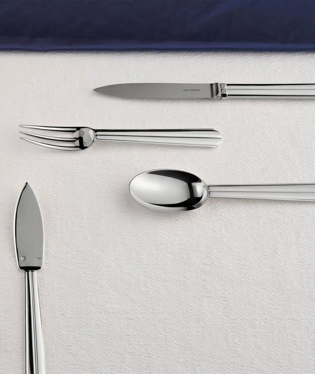 Couverts Chantaco sur une nappe blanche avec un filet bleu