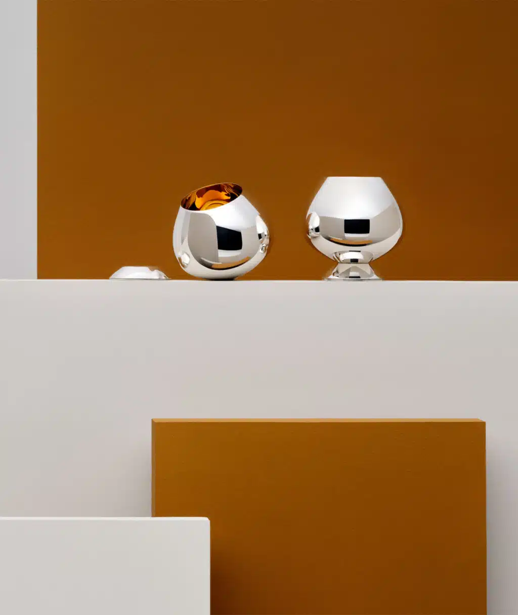 Timbales à Cognac Puiforcat sur un table blanche avec un fond orange