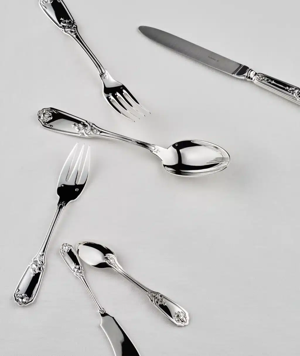 Couverts Molière Mascaron sur une nappe blanche