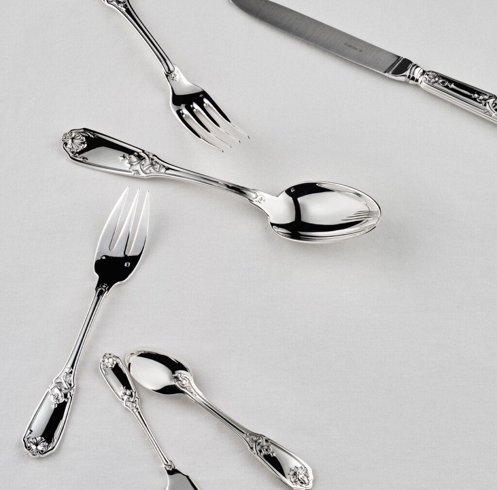 Couverts Molière Mascaron sur une nappe blanche