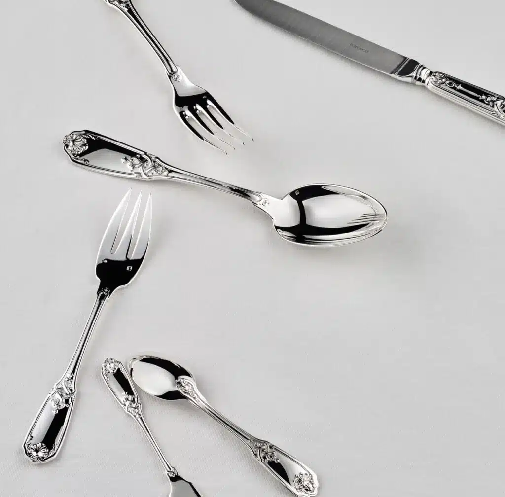 Couverts Molière Mascaron sur une nappe blanche