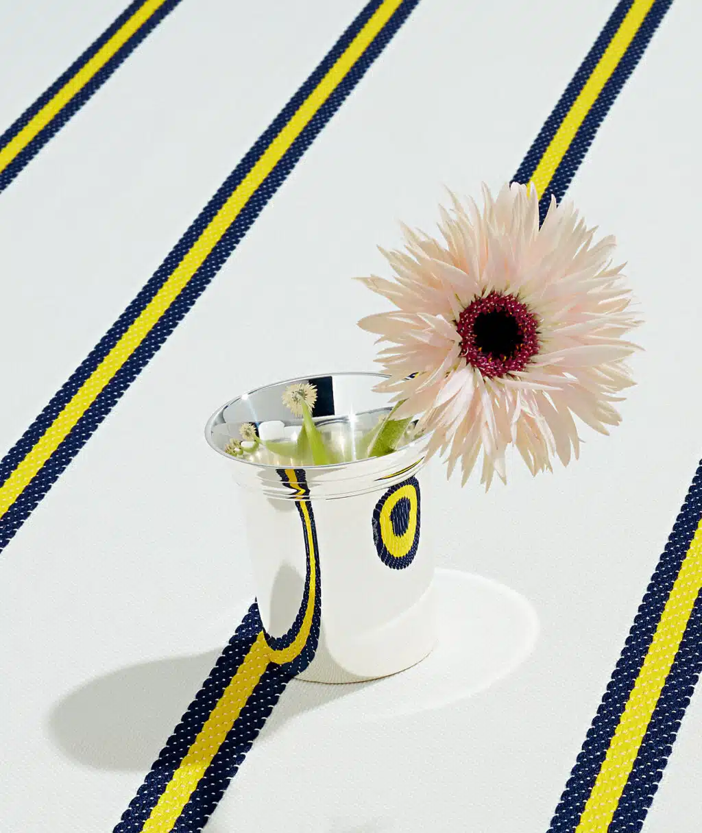 Timbale Myosotis sur nappe à rayures avec une fleur dedans