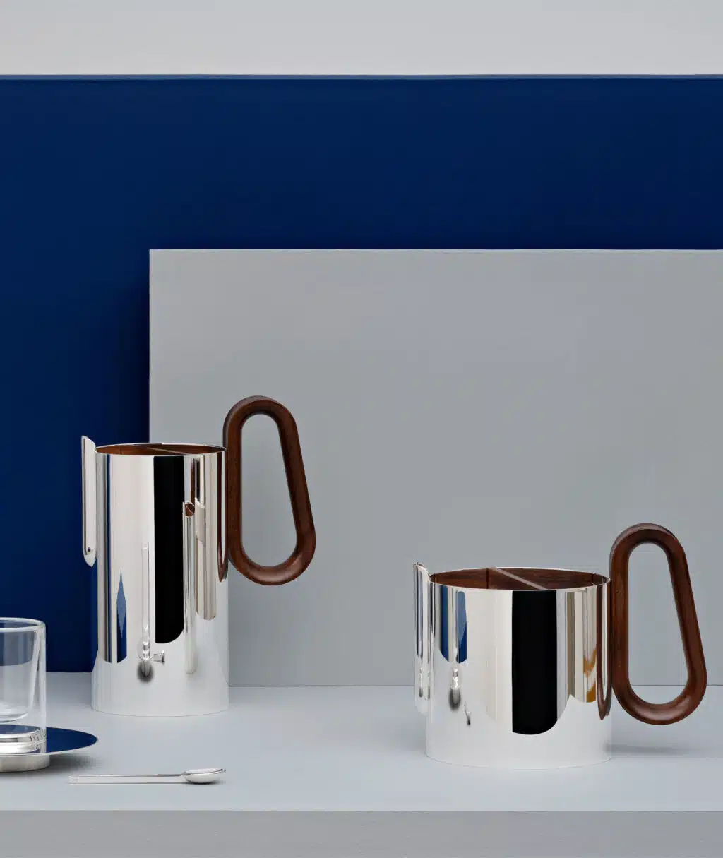 Cafetière, théière et tasse à expresso PHI sur une stèle grise avec un fond bleu et gris