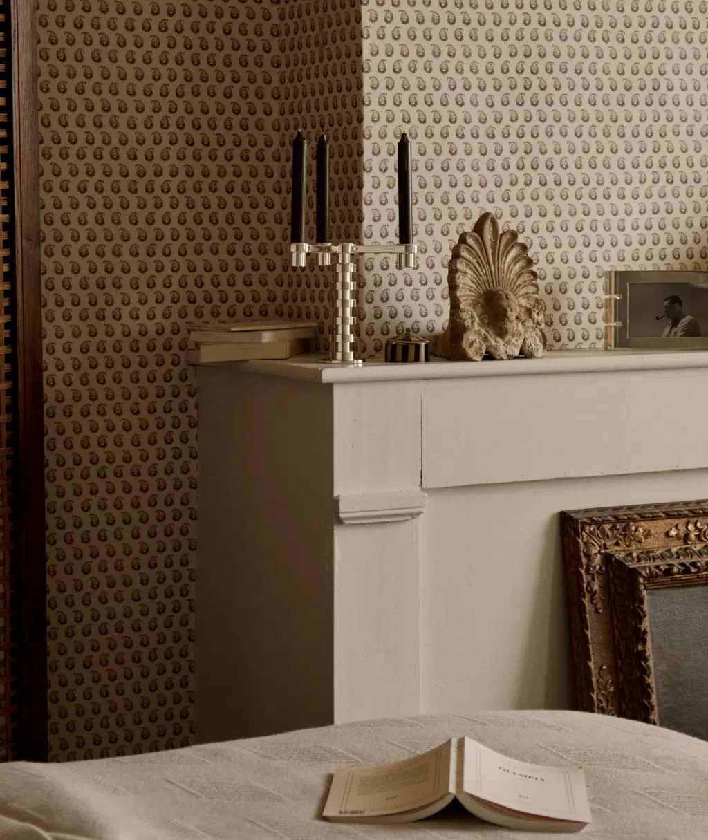 Candélabre Ruban sur une cheminée devant un papier peint