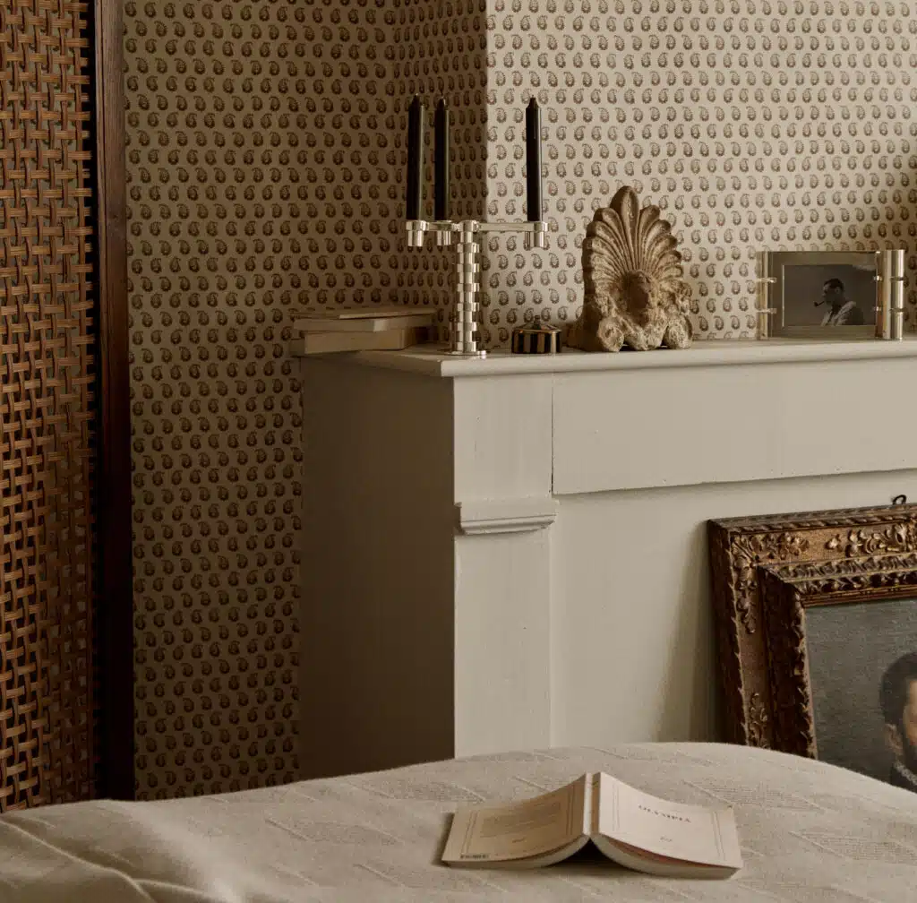 Candélabre Ruban sur une cheminée devant un papier peint