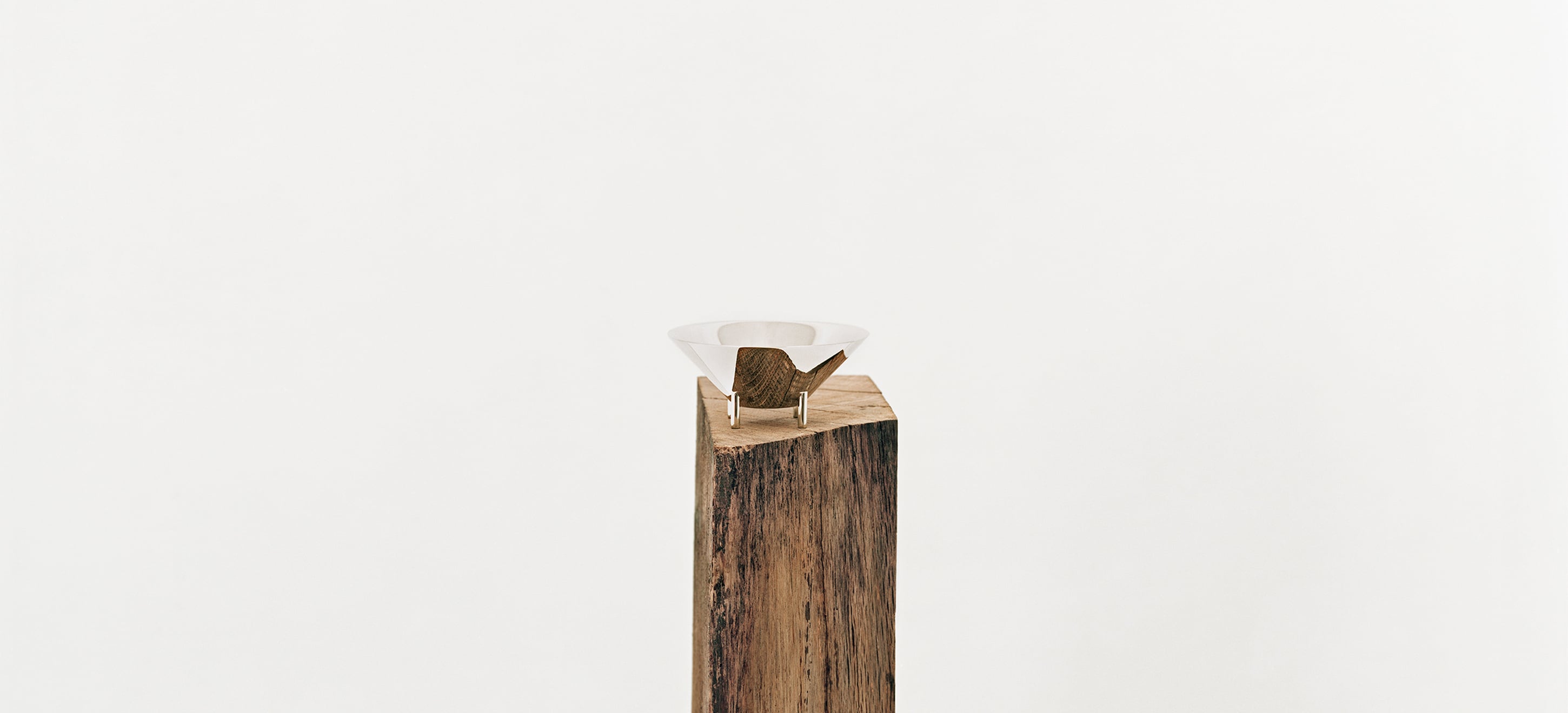 Verre 02 de la collection Kanmi, réalisée en collaboration avec Tomás Alonso, posé sur une poutre en bois